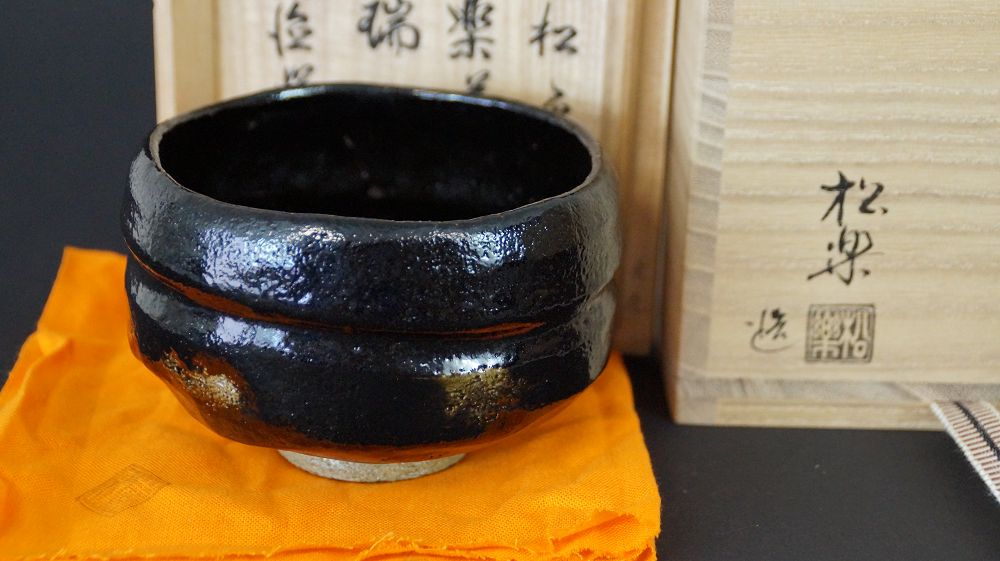Chawan Teeschale aus Raku-Keramik von Shoraku Sasaki vor der signierten Aufbewahrungsbox mit Kuenstlersiegel