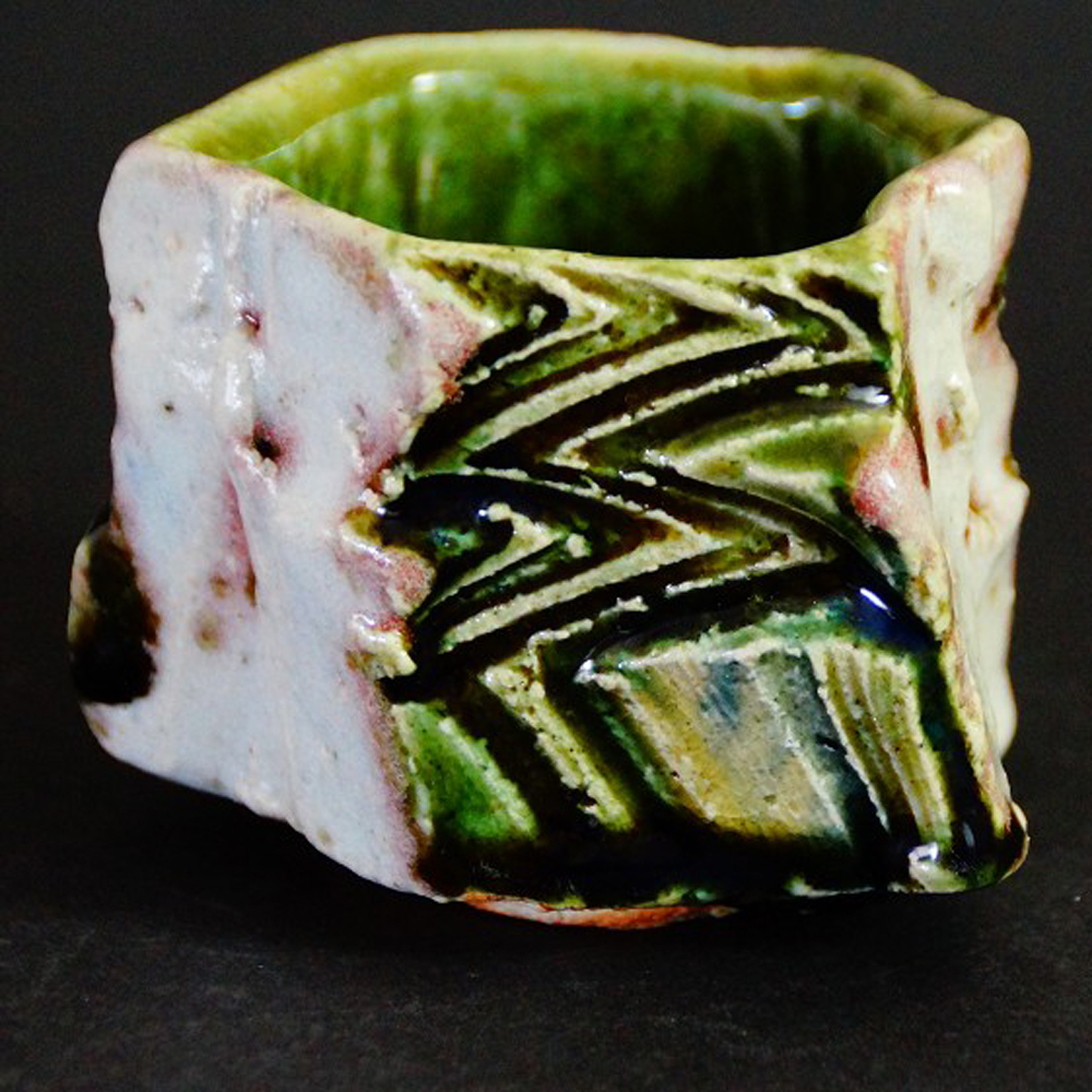 Guinomi avec glaçure Oribe verte et champ de contraste blanc par Kawachi Hidetoshi devant la boîte de rangement