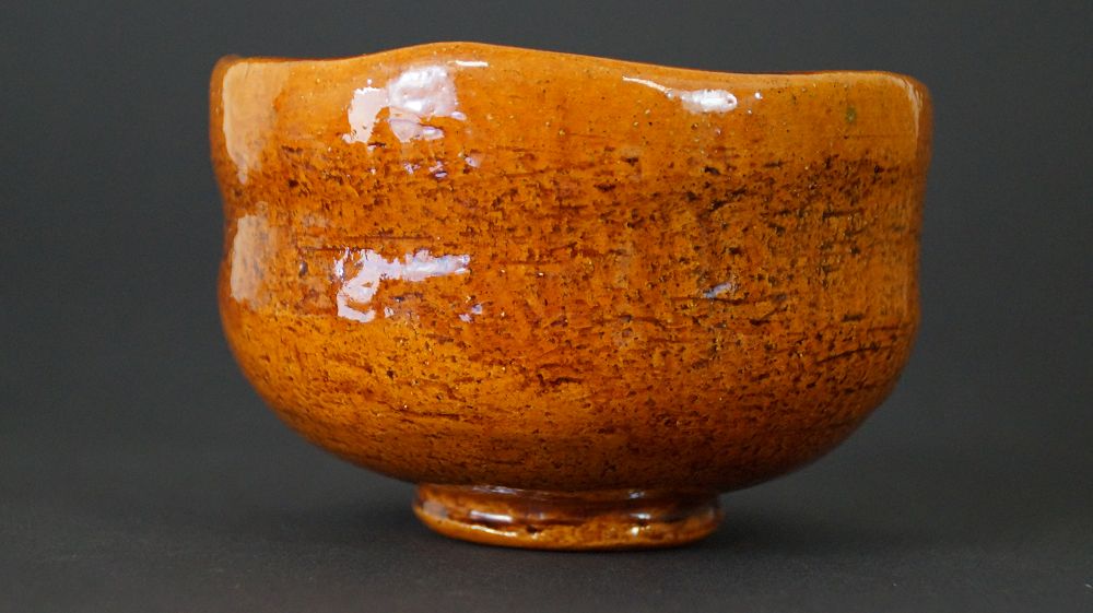 Ameyu-glasierte Teeschale (Chawan) von Ōhi Chōraku in bernsteinfarbenem Ton, Detailansicht.