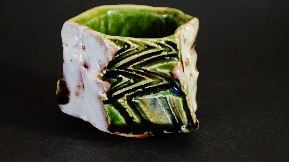 Vue de côté du guinomi anguleux avec glaçure Oribe verte par Kawachi Hidetoshi