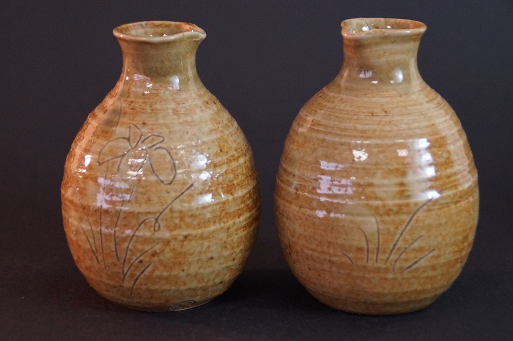 Vue de face des deux flacons à saké en céramique de Seto tournés à la main avec motif d'iris