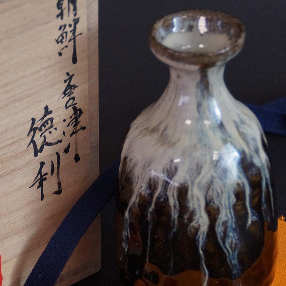 Aperçu gros plan du flacon à saké en céramique de Karatsu avec boîte de rangement en arrière-plan