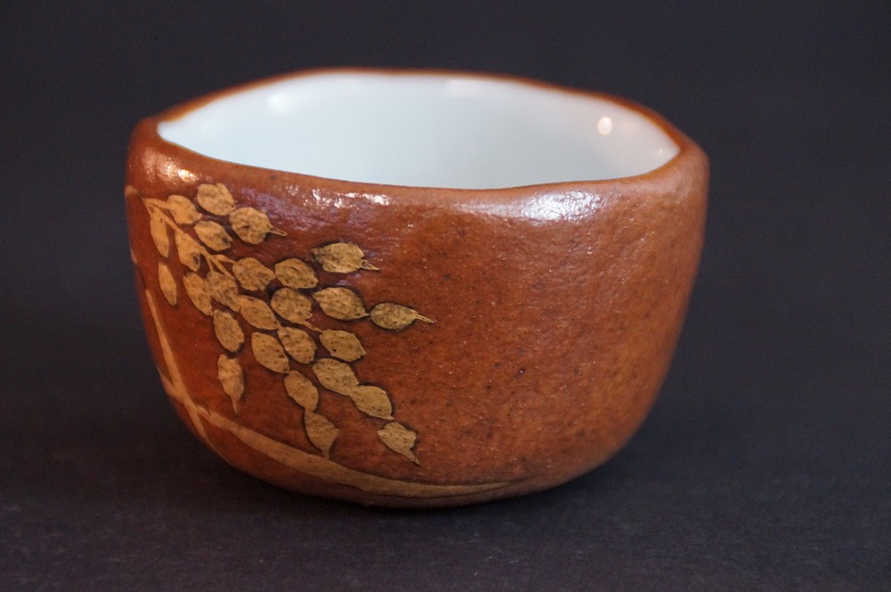 Vue de face de la coupe à saké de Kyo tournée à la main avec motif de branche dorée