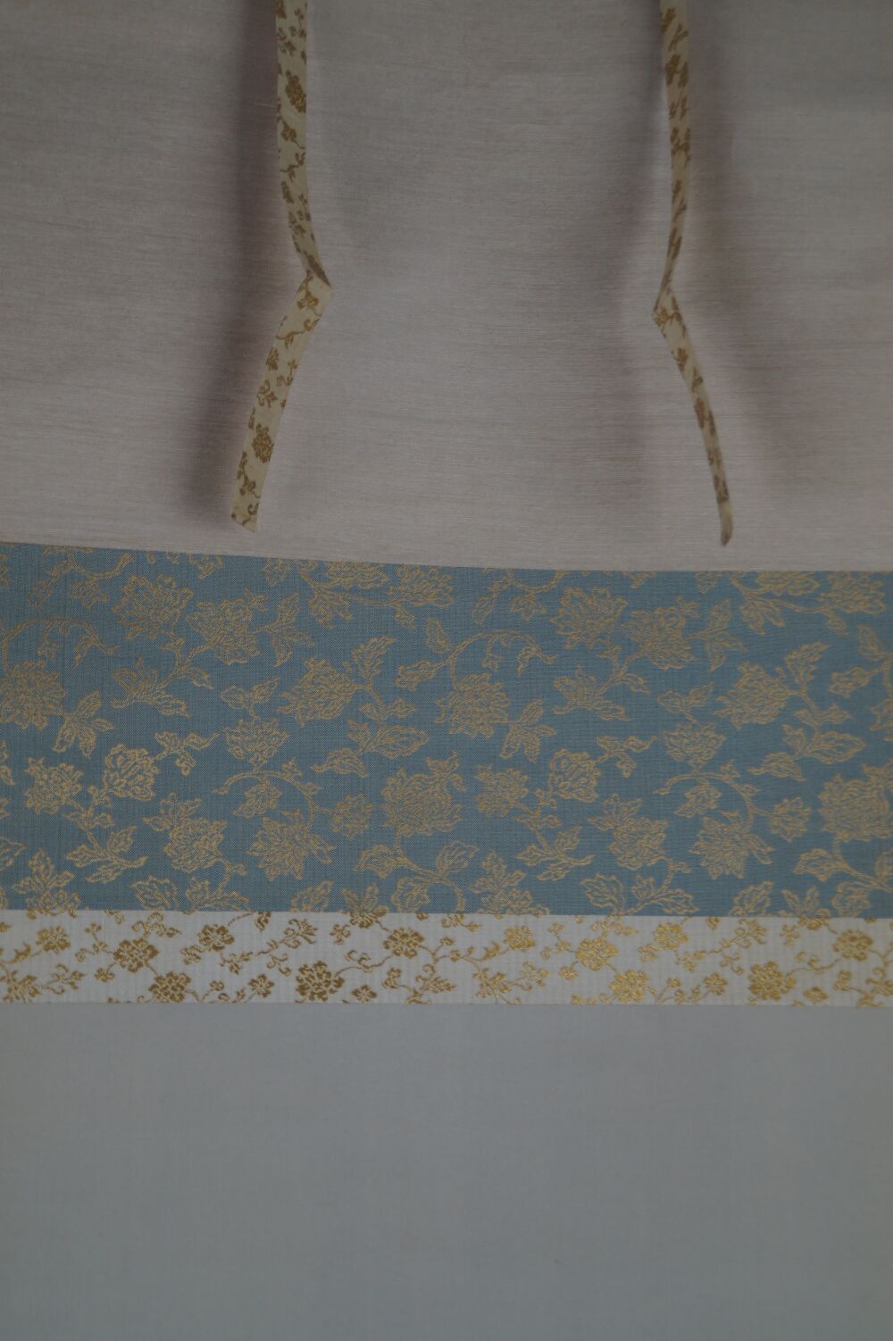 Detailansicht der Seidenmontierung mit Blumenbrokat und Aufhaengebaendern des Kakemono