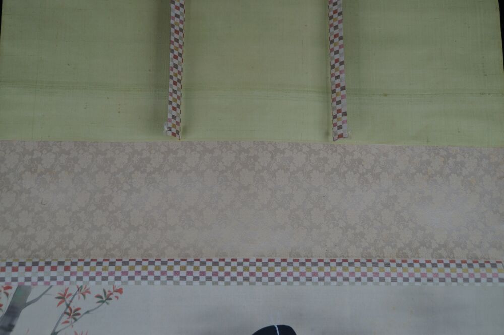 Detailansicht der Seidenmontierung mit hellgruener Seide, Karomuster-Baendern und beigem Brokat des Kakemono Dame im Kimono am Gartenteich