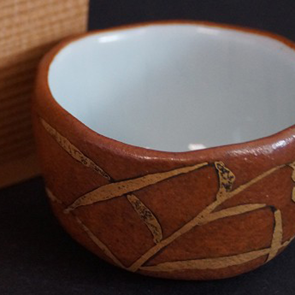 Aperçu gros plan de la coupe à saké Kyo avec boîte de conservation en arrière-plan