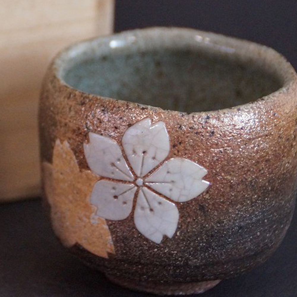Aperçu en gros plan de la coupelle à saké Karatsu avec motif de fleurs de cerisier
