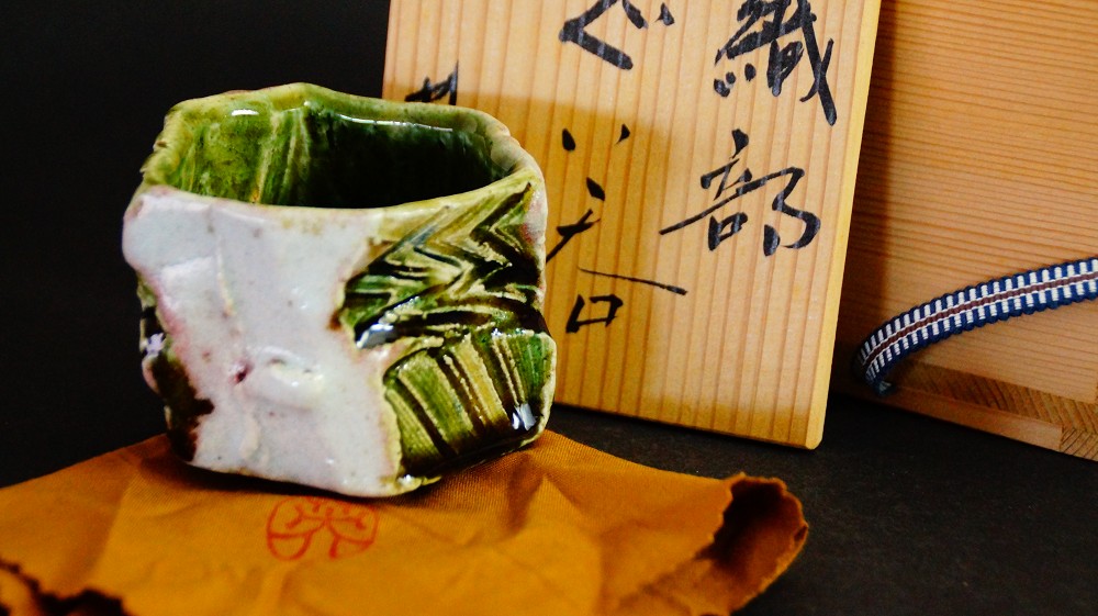 Oribe-glasierter Sake-Becher (Guinomi) von Kawachi Hidetoshi mit charakteristischer grün-weißer Glasur, Detailansicht.